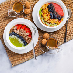 two bowls with different Smoothies from strawberries and kiwi, with Cereals for a healthy Breakfast and berries, chia seeds and coconut chips . Wheat bran and Cornflake. super food. copy space