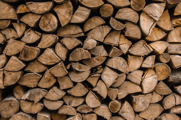 Background texture of stacked split firewood. Pile of firewood.