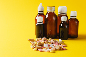 Medication white colorful round tablets arranged abstract on yellow color background. Bottle vial capsule pills for design. Health treatment choice healthy lifestyle concept. Copy space advertisement.