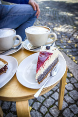 Street cafe in Weimar, Germany. Two cups of coffee latte and a piece of cake