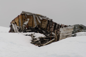 Old wooden boat broken on snow in Antarctica