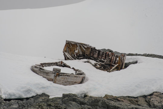 Old wooden boat broken on snow in Antarctica
