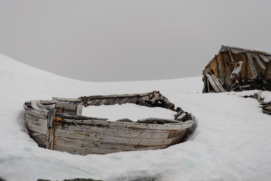 Old wooden boat broken on snow in Antarctica