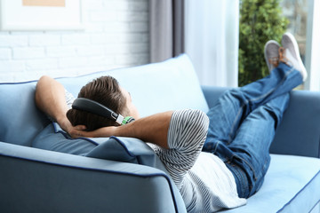 Relaxed young man listening to music at home