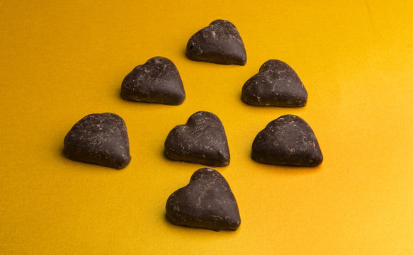 Chocolate hearts on yellow background