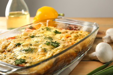 Glass baking dish with delicious casserole on table, closeup. Fresh from oven
