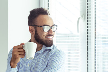 Relaxed black businessman in office, drink coffee