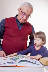 Fototapeta premium Global travel and geography concept. Portrait of happy grandfather and granddaughter looking at globe and dream of a trip.