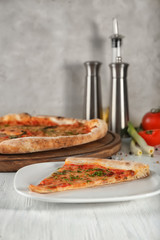 Plate with slice of pizza on table. Fresh from oven
