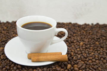 Coffee cup, straws and coffee beans on wooden background