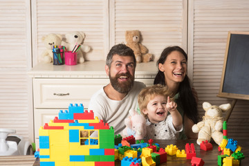 Family playing with plastic blocks and plush toys.