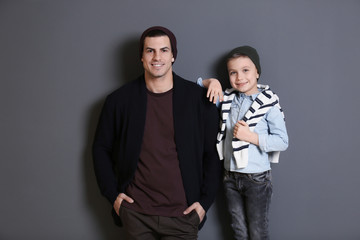 Stylish father and son on gray background