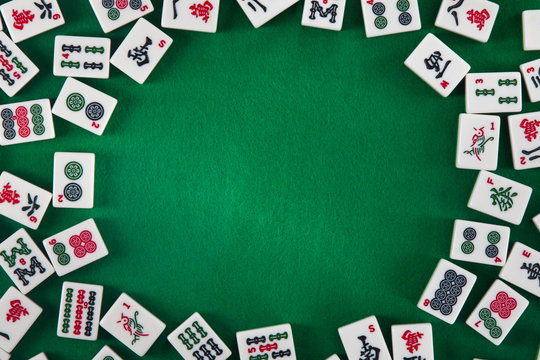 White-green tiles for mahjong on a brown wooden background. Blank space on the right