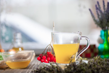 Herbal vitamin herbal tea with thyme in a transparent glass mug on a wooden table
