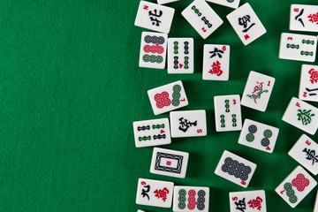 White-green tiles for mahjong on on green cloth background. Emty space on the left