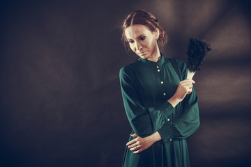 Vintage lady with feather fan on dark