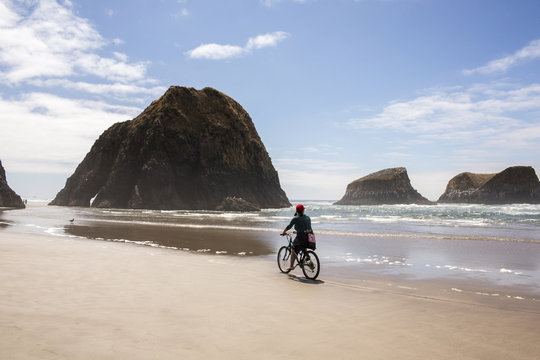 Caucasian woman riding bicycle on beach