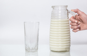 A pitcher with milk in his hand and a glass. Jug.