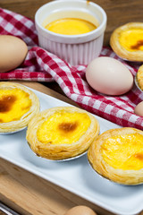 Delicious freshly baked egg tarts on wooden background