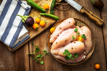 Raw chicken breast on wooden background