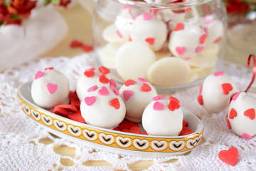 White chocolate sweets and cake pops decorated with little confectionery hearts