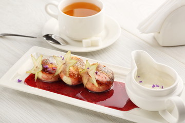 Cottage cheese pancakes with strawberry jam, sour cream on white wooden background, breakfast or lunch, tea
