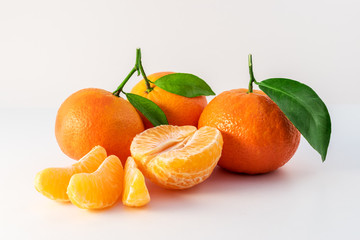 Whole tangerines or mandarines orange fruits and peeled segments isolated on white background
