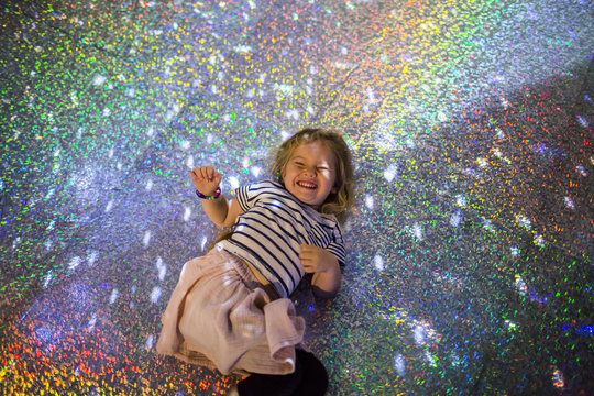 Caucasian girl laying on floor under disco ball