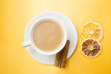 I love coffee concept. Coffee cup and sun dried orange on yellow background. Closeup and top view