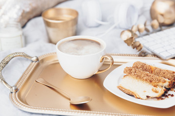 Luxury breakfast in bed. Gold tray with cup of coffee and biscuit
