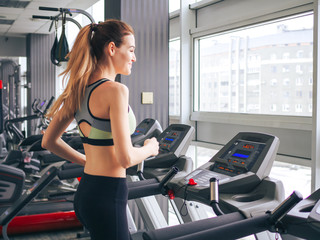 Fototapeta premium Young girl makes exercises at the gym