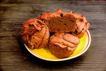 muffins on a yellow plate on a black wooden background
