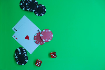 Poker concept with chips, dices and cards on green background. Top view, copy space   