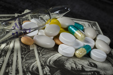Many pills on on a pile of dollars