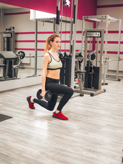 Obraz na płótnie Canvas Young girl makes exercises at the gym