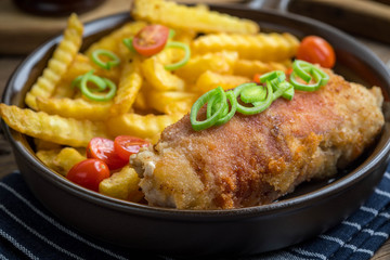 Fried chicken breast stuffed with mushrooms and cheese wrapped in ham served with fries and salad.