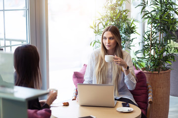 Obraz premium Young female applicant answering questions of employer during interview in cafe for new start up project