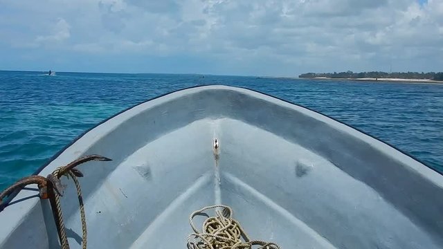 
floating plastic fishing boad on waves of a blue sea