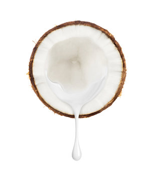 Milk flows from a slice of coconut on a white background