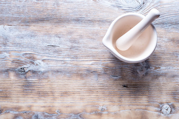 White porcelain mortar on old wood background