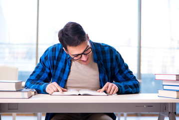 Student studying in the empty library with book preparing for ex