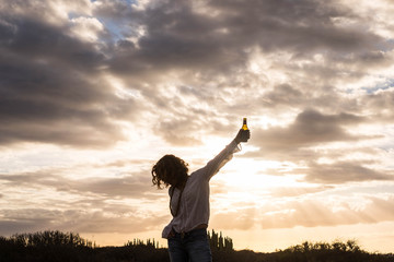 Fototapeta na wymiar rock'n roll woman with a beer in the sunset
