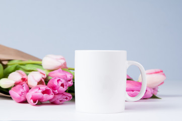Fototapeta na wymiar white mug mockup with pink tulips for spring