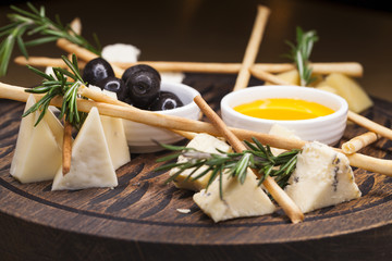 cheese sliced from different types of cheese with honey and olives