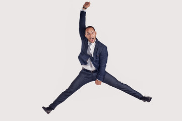A businessman in a suit jumps for joy.
The guy jumps happily.