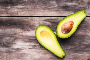 Fresh avocado sliced over vintage wooden background © bbstudio_ada