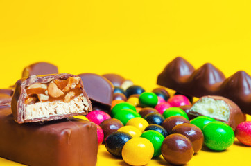 chocolate bars, colorful candy, sweets on a yellow background