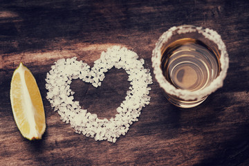 Tequila shot with lime fruit slice and heart shape made from salt 
