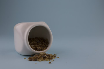 raw cane sugar inside a white ceramic jar with wooden stopper