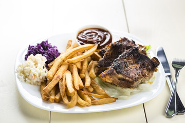 baked ribs and French fries and cabbage salad